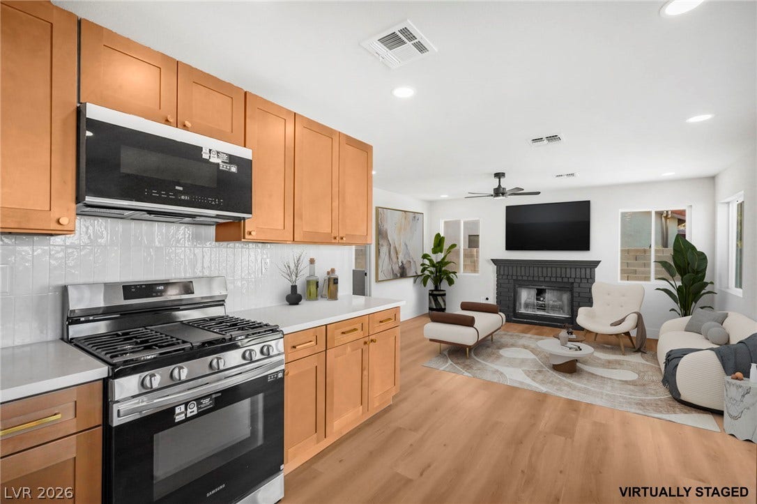 Warm wood cabinetry and durable hard surface flooring enrich this light-filled open concept space.