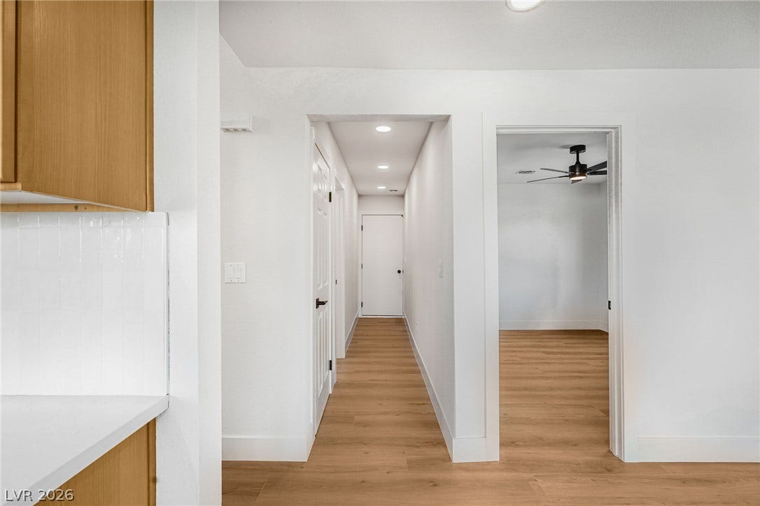 Smooth wood floors connect the open hallways and transition seamlessly into nearby rooms.