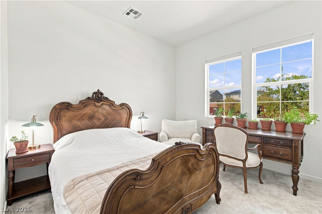 5745 N Golden Chase Court, Las Vegas, NV 89131 Natural light streams through multiple windows into this carpeted bedroom.