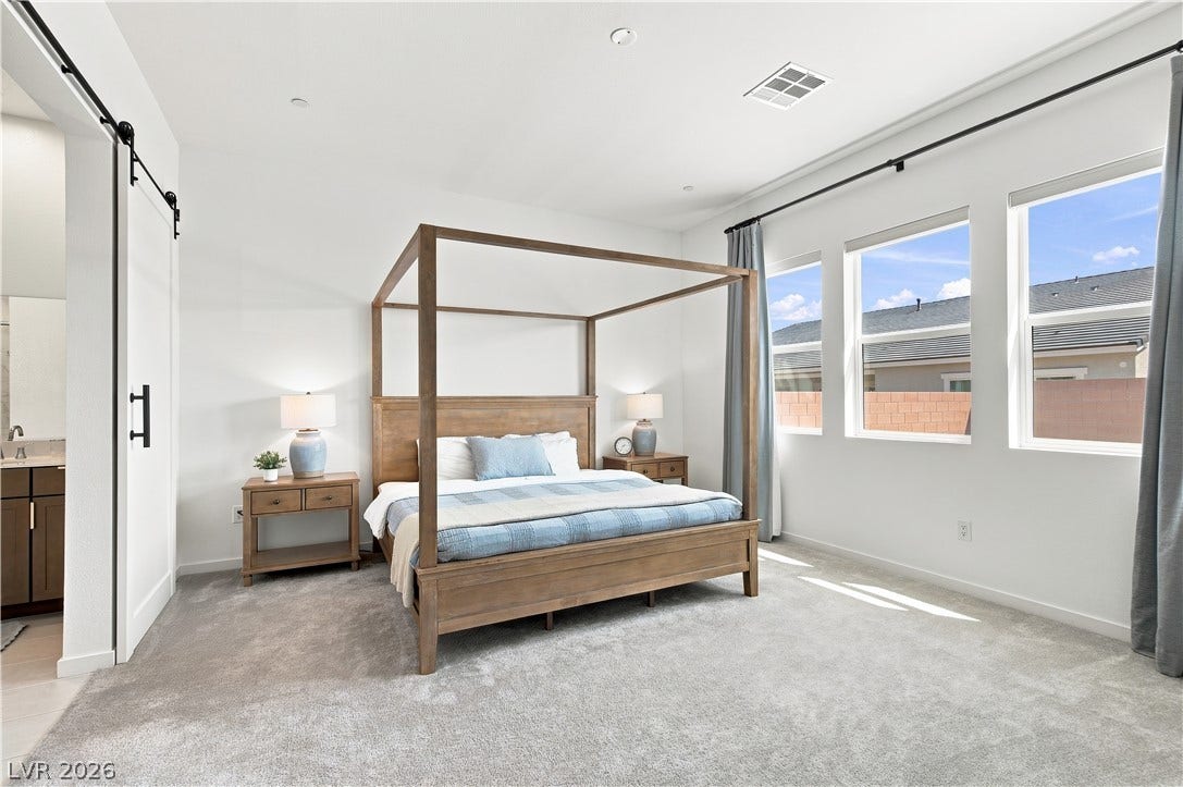 5745 N Golden Chase Court, Las Vegas, NV 89131 Generous natural light streams across the carpeted flooring and high ceilings of this bedroom.