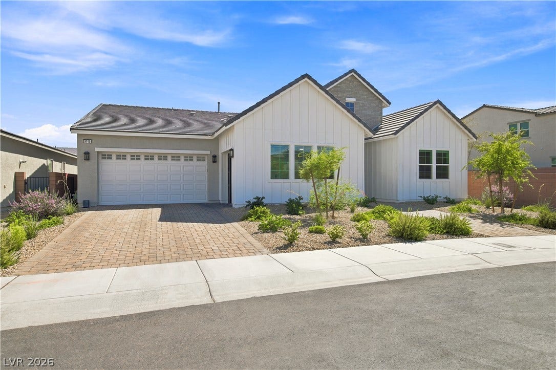5745 N Golden Chase Court, Las Vegas, NV 89131 Striking board and batten siding pairs beautifully with stone accents and a paved driveway.