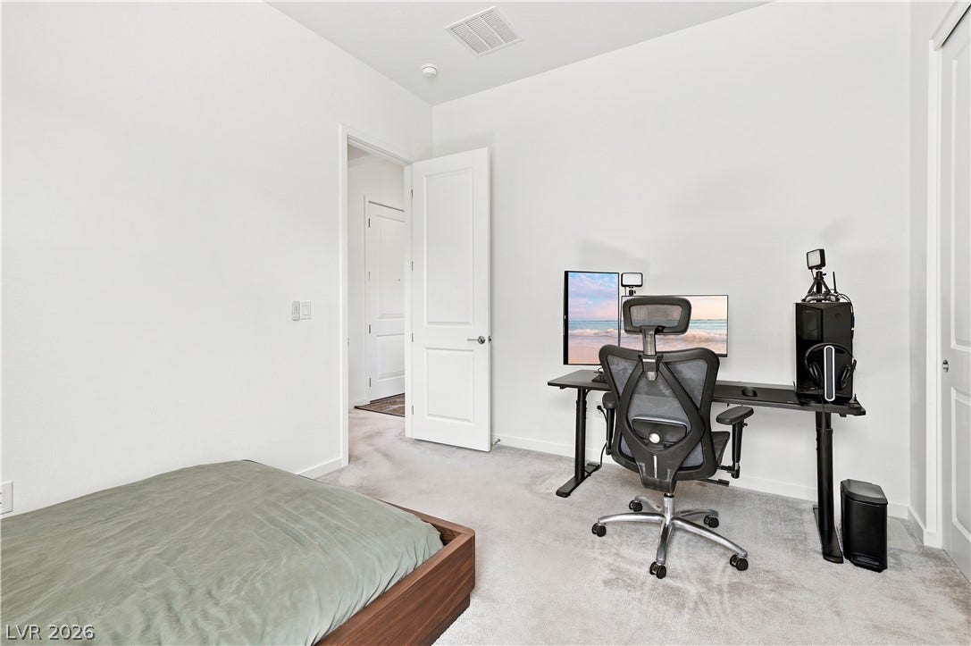 5745 N Golden Chase Court, Las Vegas, NV 89131 A versatile extra bedroom offers plush wall-to-wall carpeting and clean minimalist lines.