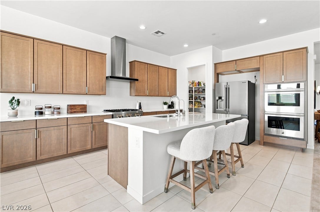 5745 N Golden Chase Court, Las Vegas, NV 89131 Gleaming stone countertops and matching cabinetry surround a central island in this culinary space.