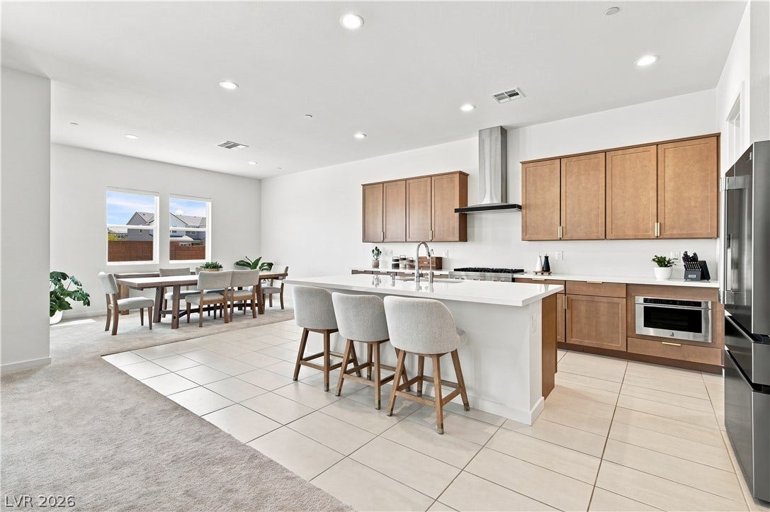 5745 N Golden Chase Court, Las Vegas, NV 89131 An open kitchen boasts a central island and seamless transition to the dining area.