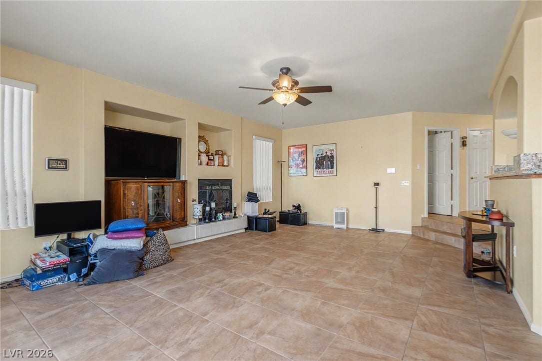 Tiled flooring and a built-in fireplace accent this open-concept living area.