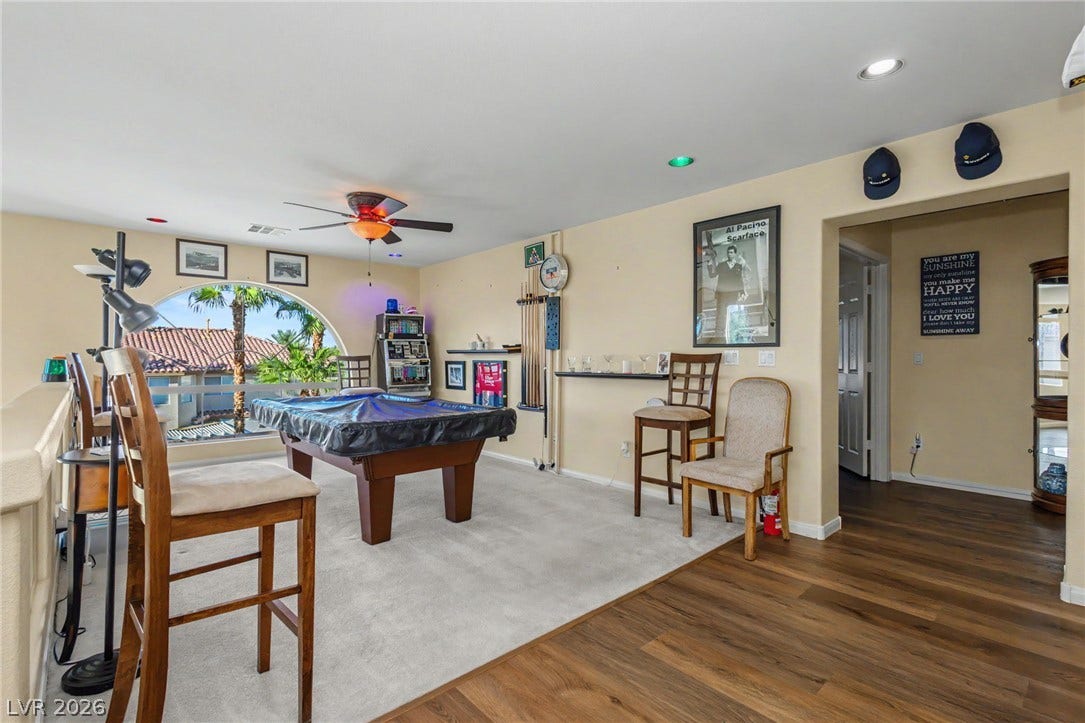 An arched window frames exterior views from this versatile upper-level recreation space.