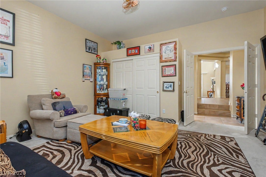 Double doors open to reveal a spacious living area with soft neutral tones.