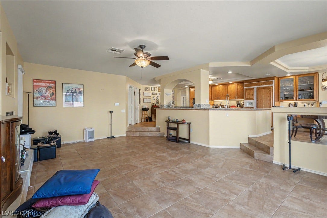 A spacious tiled layout seamlessly connects the living room to the elevated kitchen area.