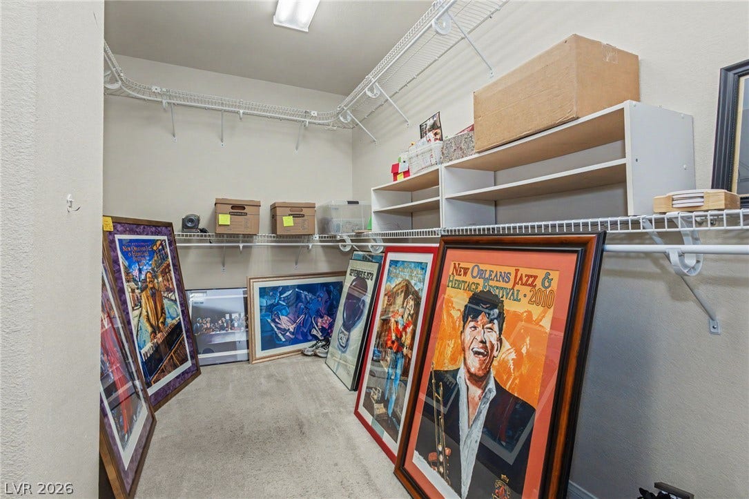 Organized storage and display opportunities await within this carpeted walk-in closet space.