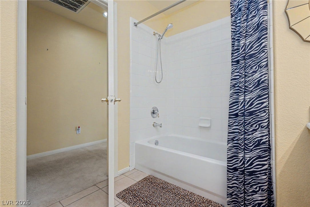 Clean tile surrounds the shower and tub combination in this practical bathroom setup.