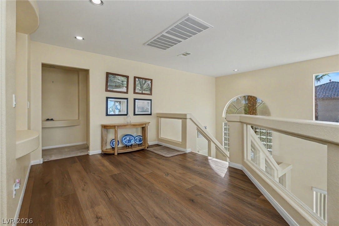 Gleaming hardwood floors and a customized stairwell railing highlight this welcoming upper landing.