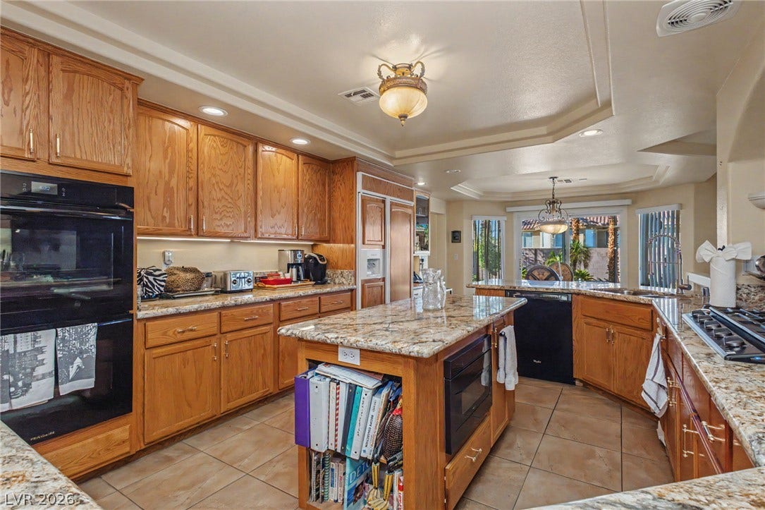 Warm wood cabinetry pairs with stone countertops in this functional kitchen layout.