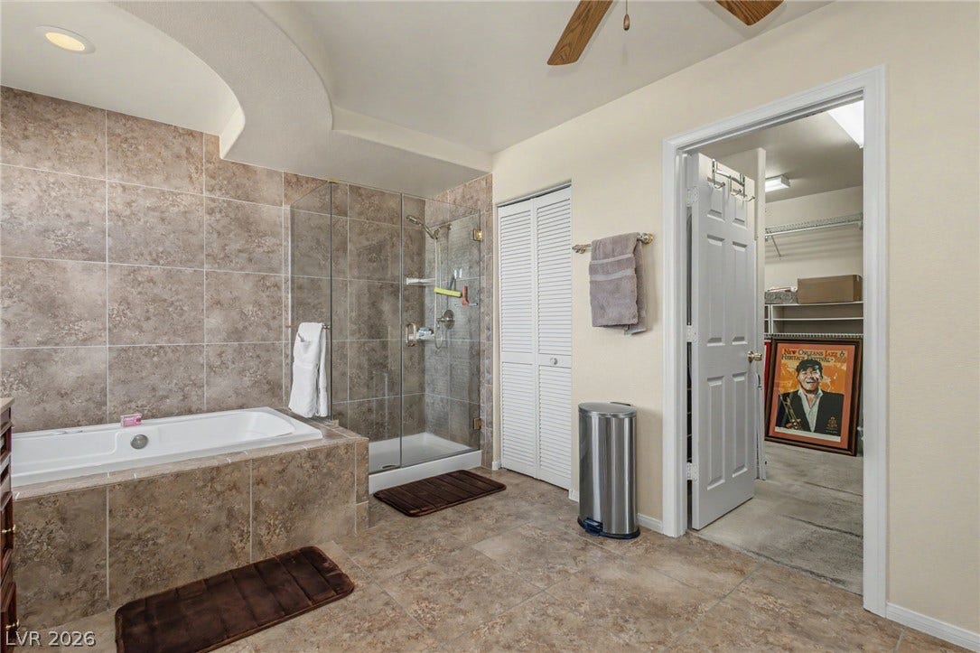A spacious bathroom features a tile-surround soaking tub and adjacent walk-in shower.