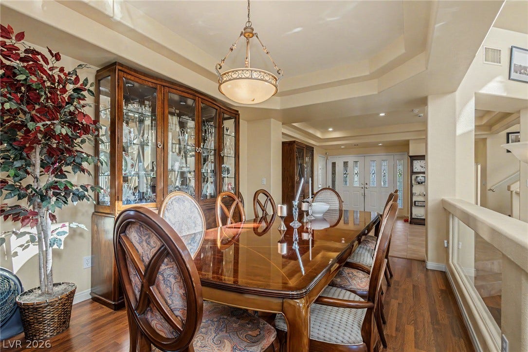 Rich hardwood floors and elegant tray ceilings create a sophisticated atmosphere in this formal dining area.