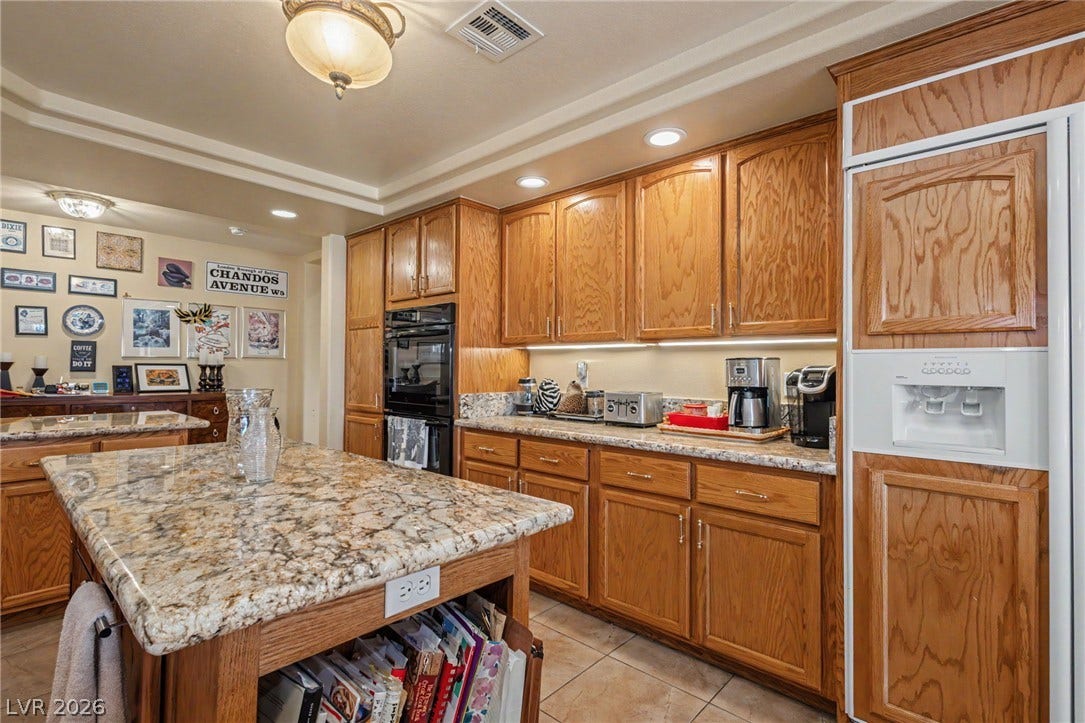 Rich wood cabinetry and polished stone countertops define this functional kitchen space.