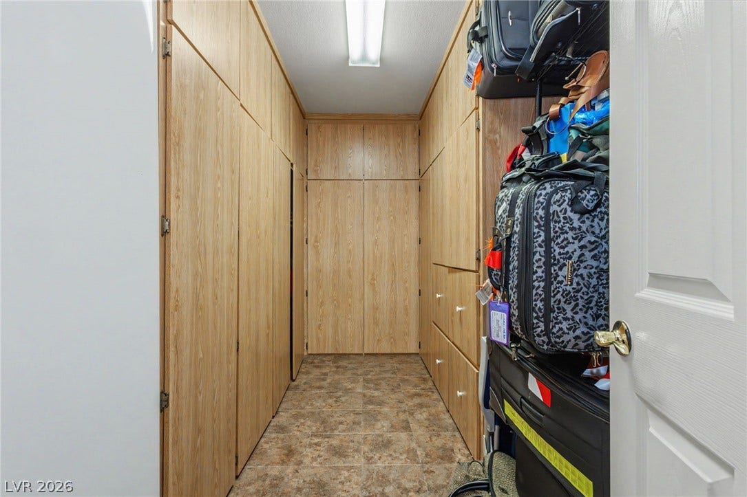 Floor-to-ceiling wooden built-ins maximize storage potential above the textured tile flooring.