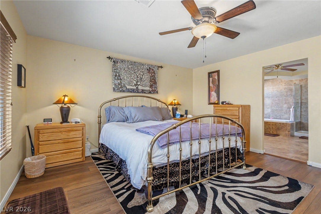 Rich wood-look flooring anchors this comfortable bedroom suite opening directly to the private bath.