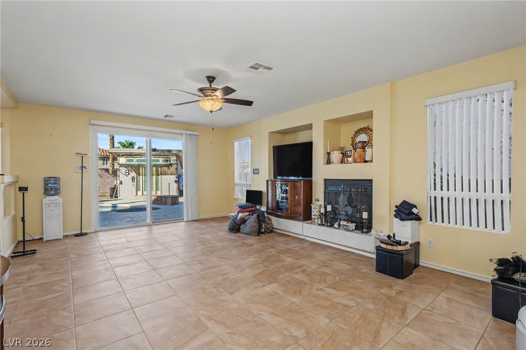 Tiled flooring and a built-in fireplace accent this open space with sliding doors.
