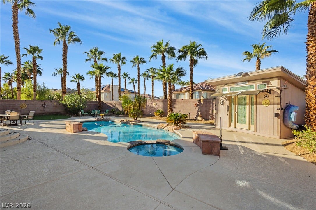 An inviting backyard oasis features a sparkling in-ground pool paired with a custom pool house.