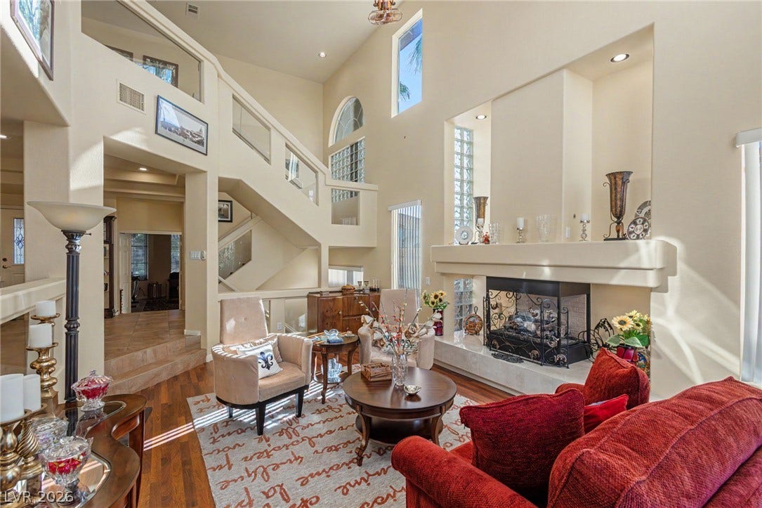 Towering ceilings and a grand fireplace anchor this impressive multi-level living area.