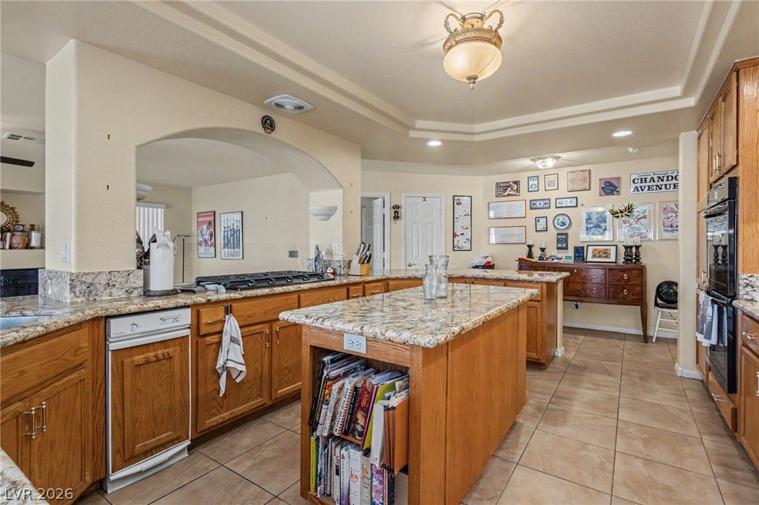 Warm oak cabinetry and premium stone countertops define this exceptionally functional kitchen space.