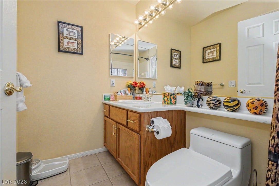 A classic vanity with wooden cabinetry anchors this functional bathroom space.