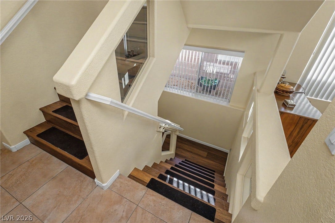Multi-level staircases featuring rich wood steps lead through a bright architectural layout.