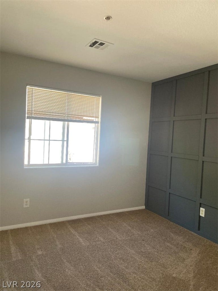 3025 Sunrise Bay Avenue, North Las Vegas, NV 89031 A classic window illuminates plush carpeting and custom paneled millwork in this cozy bedroom.