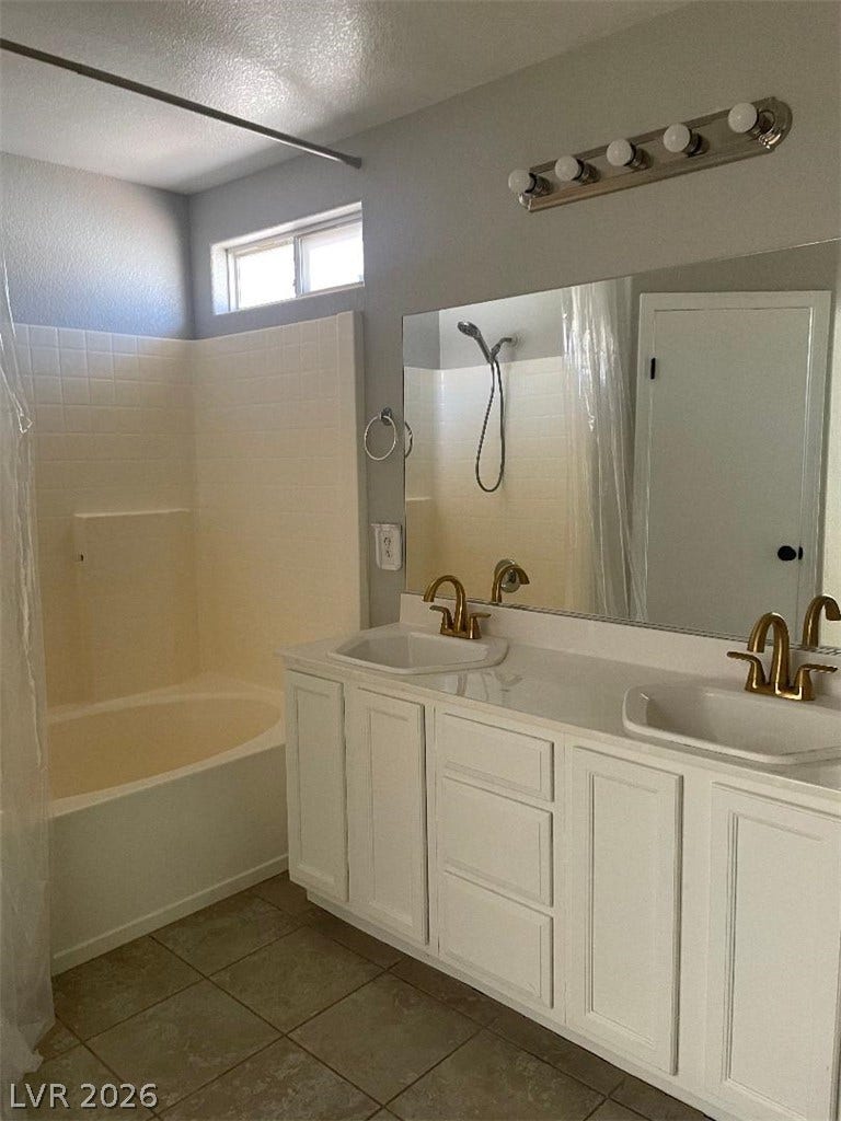 3025 Sunrise Bay Avenue, North Las Vegas, NV 89031 Gold fixtures bring warmth to the double vanity and soaking tub setup.
