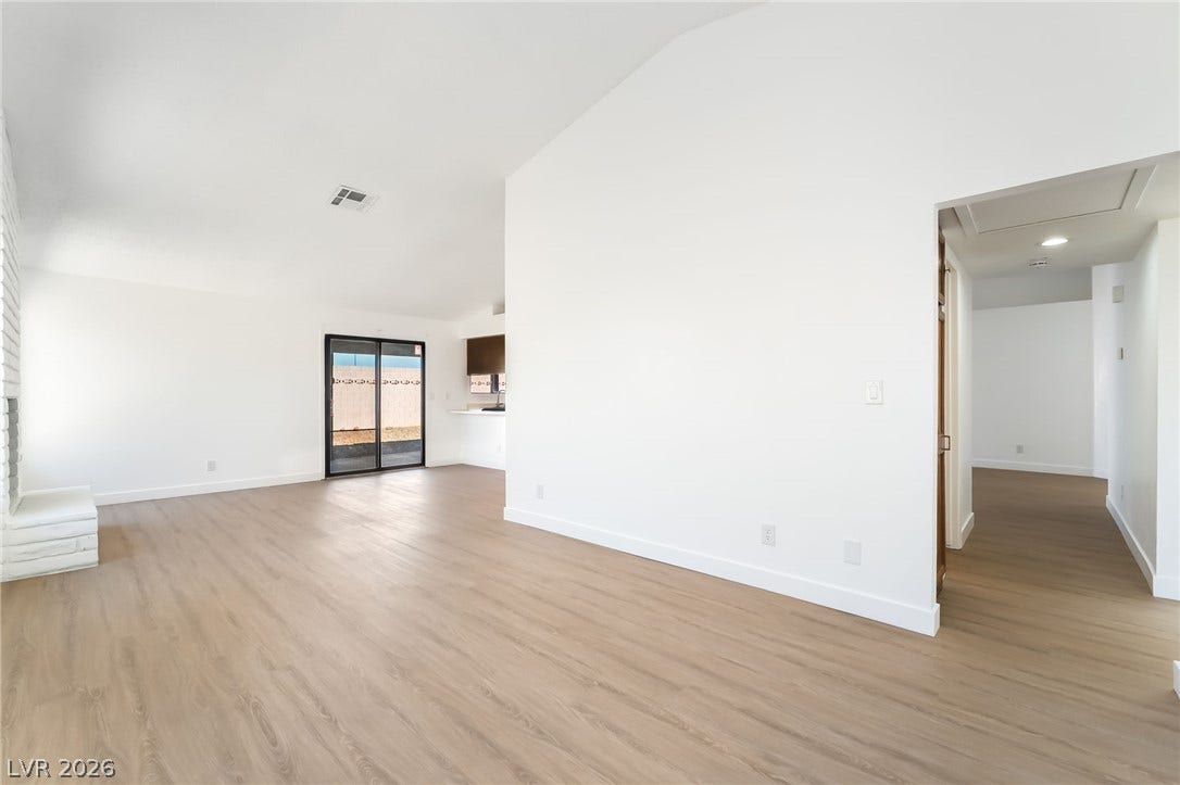 838 Anchor Drive, Henderson, NV 89015 Smooth wood-look flooring stretches across a spacious, open living area with clean white walls.