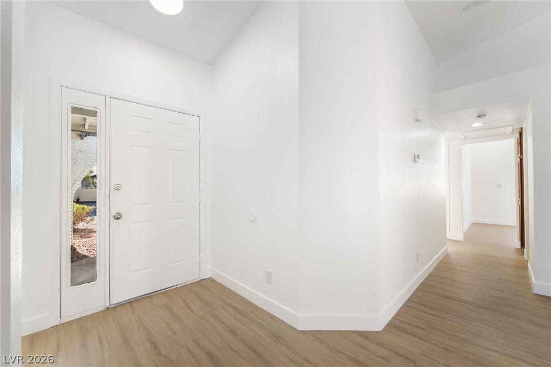 838 Anchor Drive, Henderson, NV 89015 Crisp white walls and wood-look flooring create a welcoming entrance foyer under vaulted ceilings.