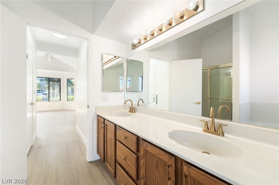 838 Anchor Drive, Henderson, NV 89015 Double vanities with gold-tone fixtures sit beneath expansive mirrors in this sleek bathroom.