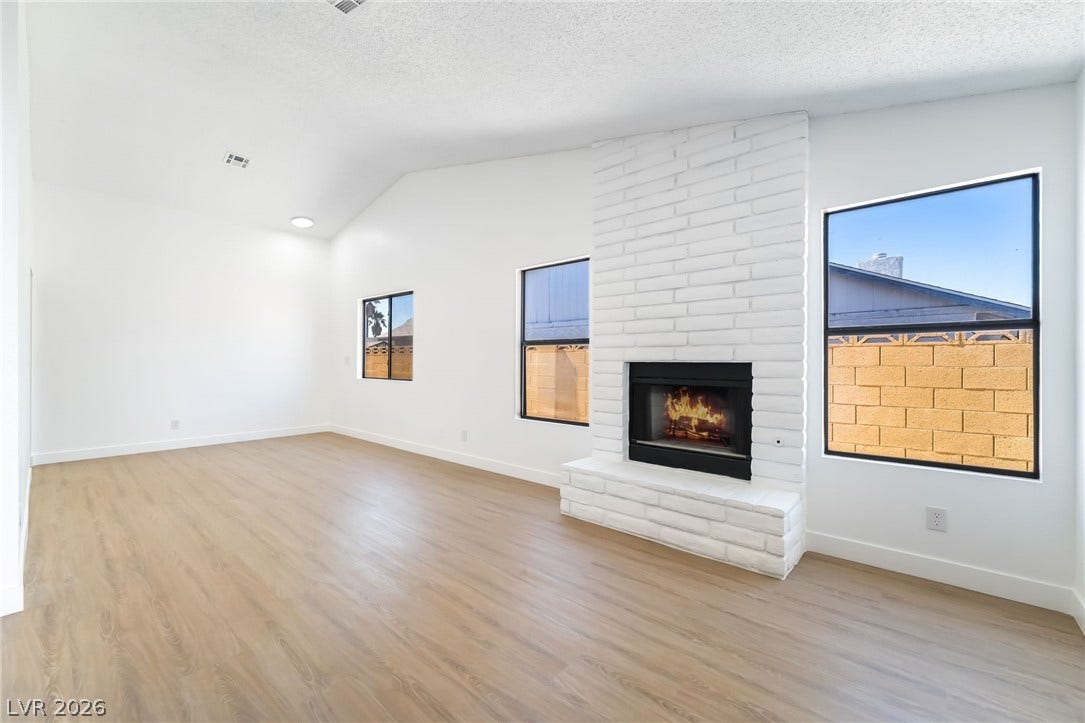 838 Anchor Drive, Henderson, NV 89015 An inviting wood-floored living area centers around a classic brick fireplace under a vaulted ceiling.