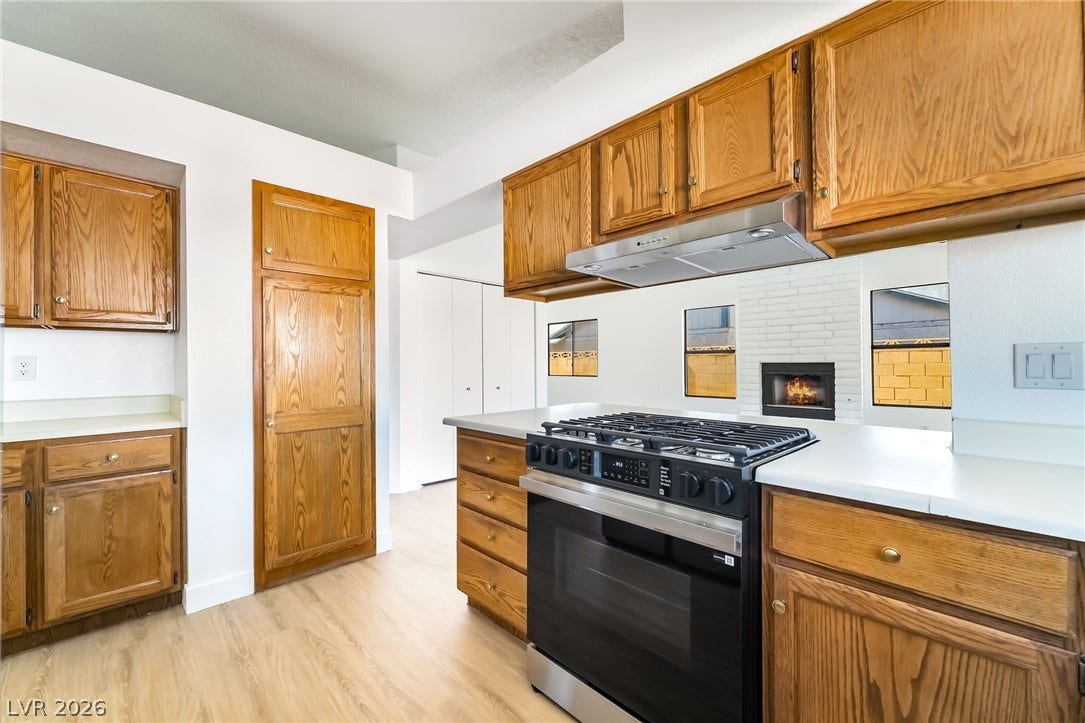 838 Anchor Drive, Henderson, NV 89015 Rich wood cabinetry contrasts with light solid-surface countertops in this classic kitchen layout.