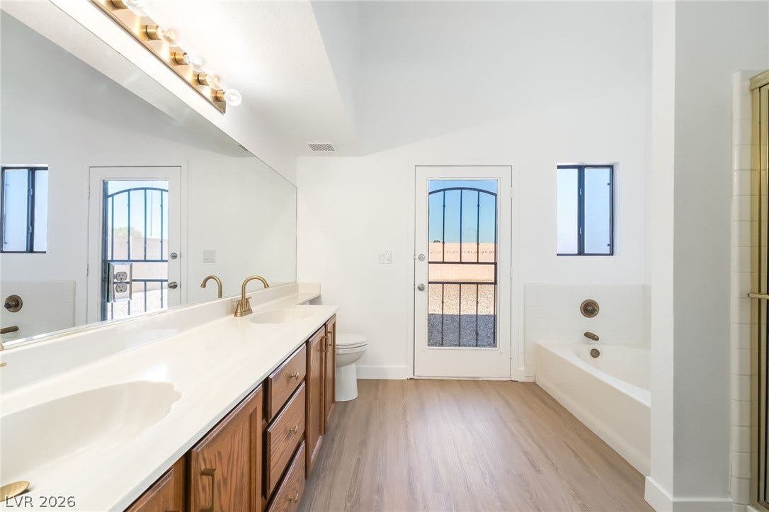 838 Anchor Drive, Henderson, NV 89015 High vaulted ceilings and wood-look flooring enhance this generous primary bathroom layout.