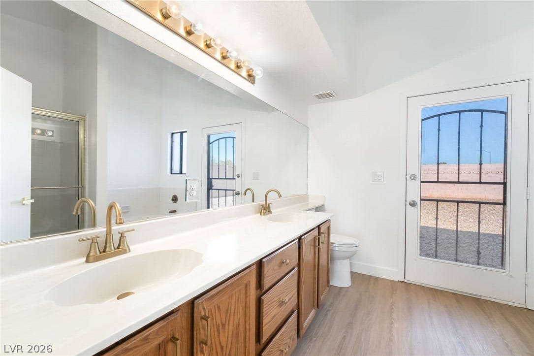 838 Anchor Drive, Henderson, NV 89015 A spacious vanity with dual sinks anchors this airy bathroom featuring direct outdoor access.