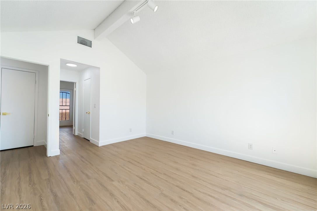 838 Anchor Drive, Henderson, NV 89015 A vaulted ceiling and wood-finish flooring define this airy bedroom space.