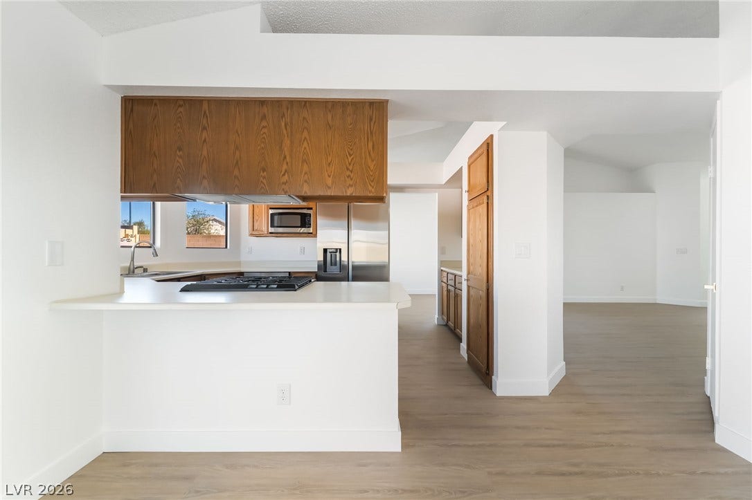 838 Anchor Drive, Henderson, NV 89015 Gleaming wood-look floors flow seamlessly from the open kitchen into the spacious living areas.