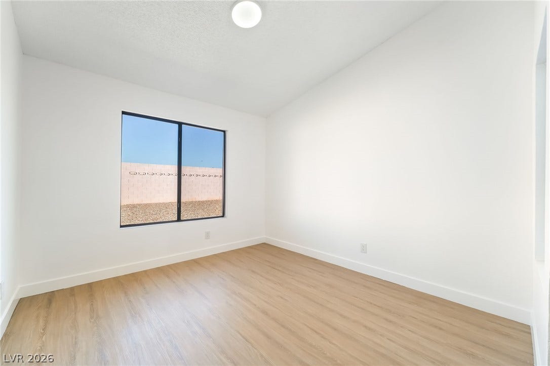 838 Anchor Drive, Henderson, NV 89015 Clean lines and warm wood-style flooring define this versatile, light-filled bedroom.