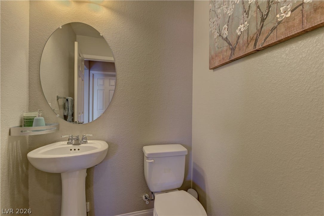 4650 Ranch House Road, #14, North Las Vegas, NV 89031 A classic pedestal sink paired with an oval mirror anchors this powder room.