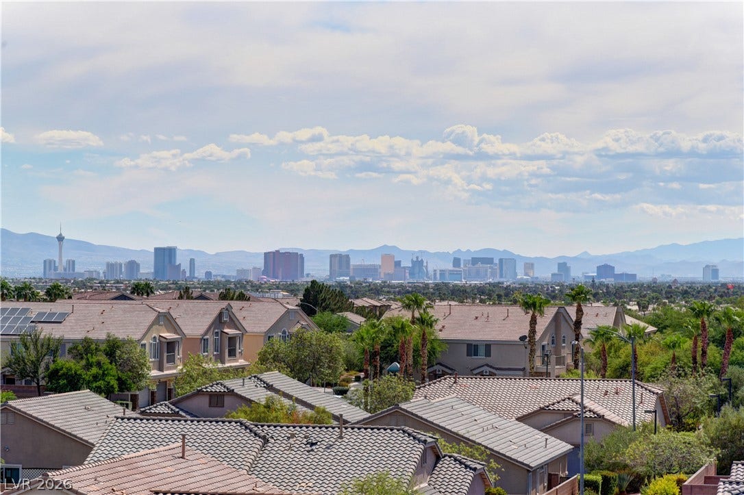 4650 Ranch House Road, #14, North Las Vegas, NV 89031 Distant skyline vistas rise above the surrounding neighborhood rooftops under a soft sky.