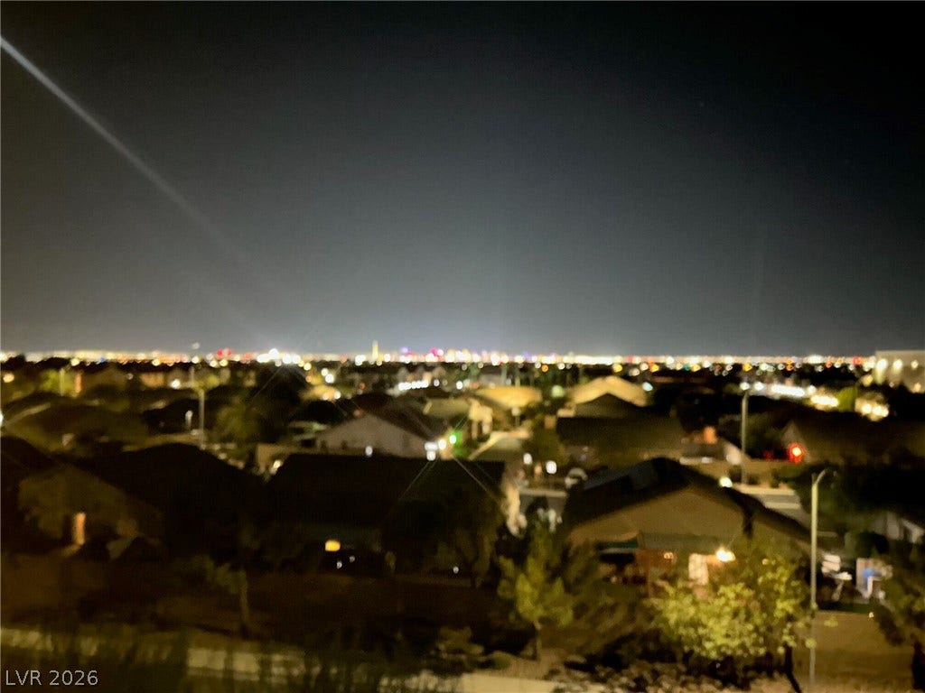 4650 Ranch House Road, #14, North Las Vegas, NV 89031 Glimmering city lights stretch across the horizon, creating a captivating night view.