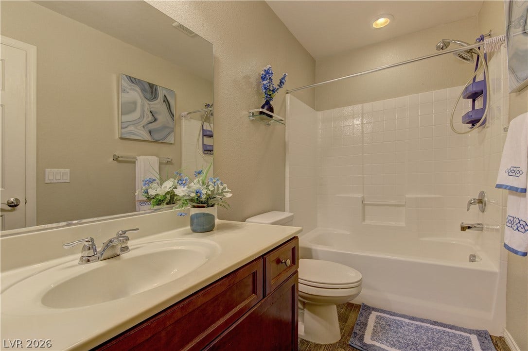 4650 Ranch House Road, #14, North Las Vegas, NV 89031 A classic tub-and-shower combination anchors this functional bathroom featuring a dark wood vanity.