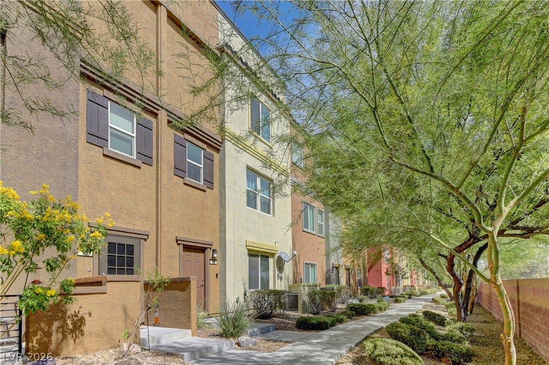4650 Ranch House Road, #14, North Las Vegas, NV 89031 A paved walkway winds past multi-level townhomes with shuttered windows and desert landscaping.