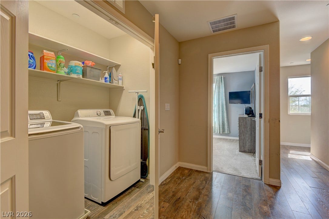 4650 Ranch House Road, #14, North Las Vegas, NV 89031 An organized laundry closet features built-in shelving above a side-by-side washer and dryer set.