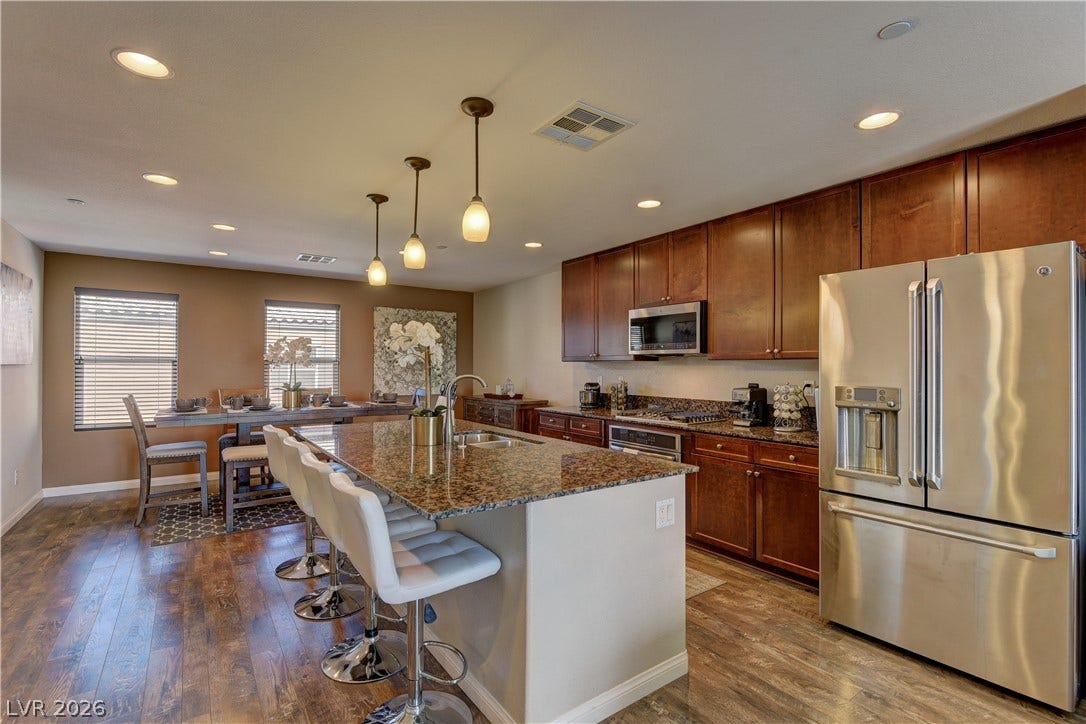 4650 Ranch House Road, #14, North Las Vegas, NV 89031 Rich wood cabinetry and expansive granite countertops define this modern, open culinary space.