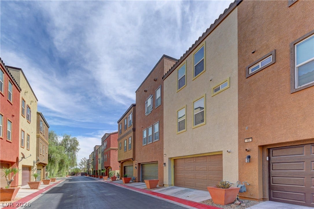 4650 Ranch House Road, #14, North Las Vegas, NV 89031 Multi-level townhomes showcase warm stucco exteriors and integrated ground-floor garages along a quiet street.