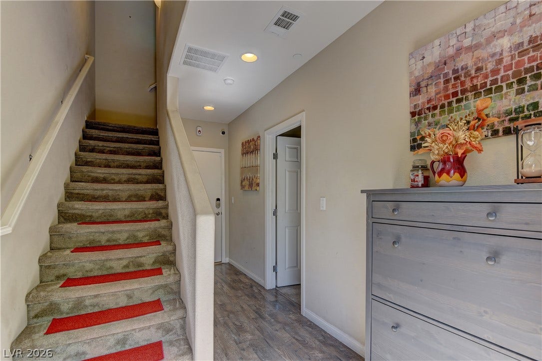 4650 Ranch House Road, #14, North Las Vegas, NV 89031 Smooth wood-look flooring guides visitors through a welcoming entryway flanked by carpeted stairs.