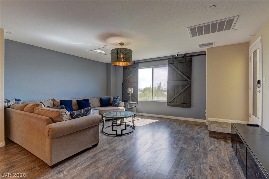 4650 Ranch House Road, #14, North Las Vegas, NV 89031 Gleaming wood-look floors anchor this airy living space complete with a rustic sliding barn door.
