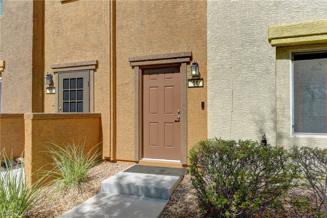 4650 Ranch House Road, #14, North Las Vegas, NV 89031 Concrete walkways lead to a private recessed entryway surrounded by desert landscaping.